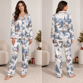 woman wearing christmas village satin pajama set in front of decorated tree