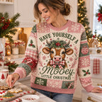 woman decorating sugar cookies while wearing cow christmas sweater in cozy kitchen