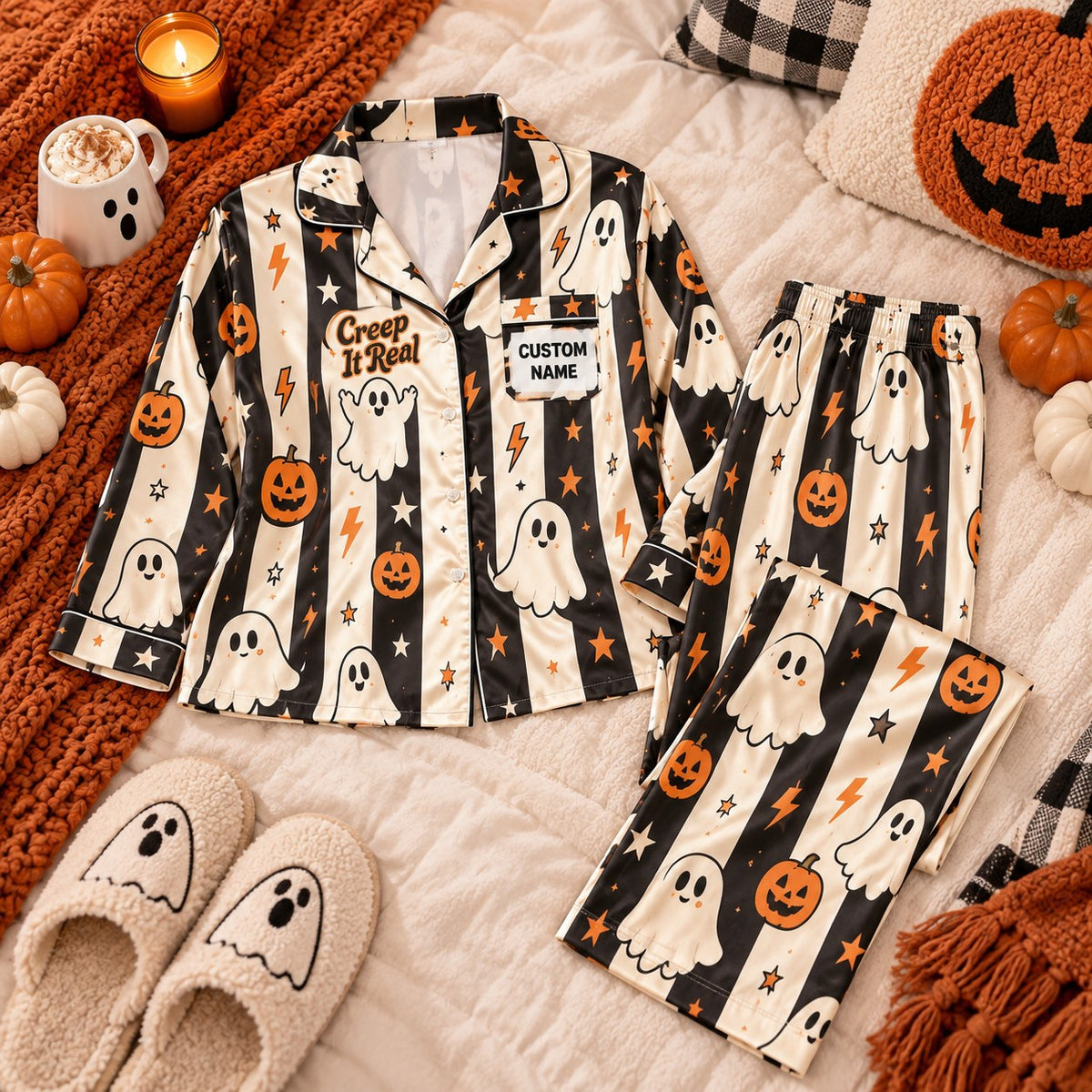 striped ghost pumpkin satin pajamas flat lay with a custom name on the chest