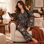 woman wearing the multicolor halloween sleepwear holding a mug by a bed