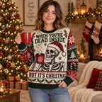 woman wearing a skeleton santa hat ugly christmas sweater holding a red