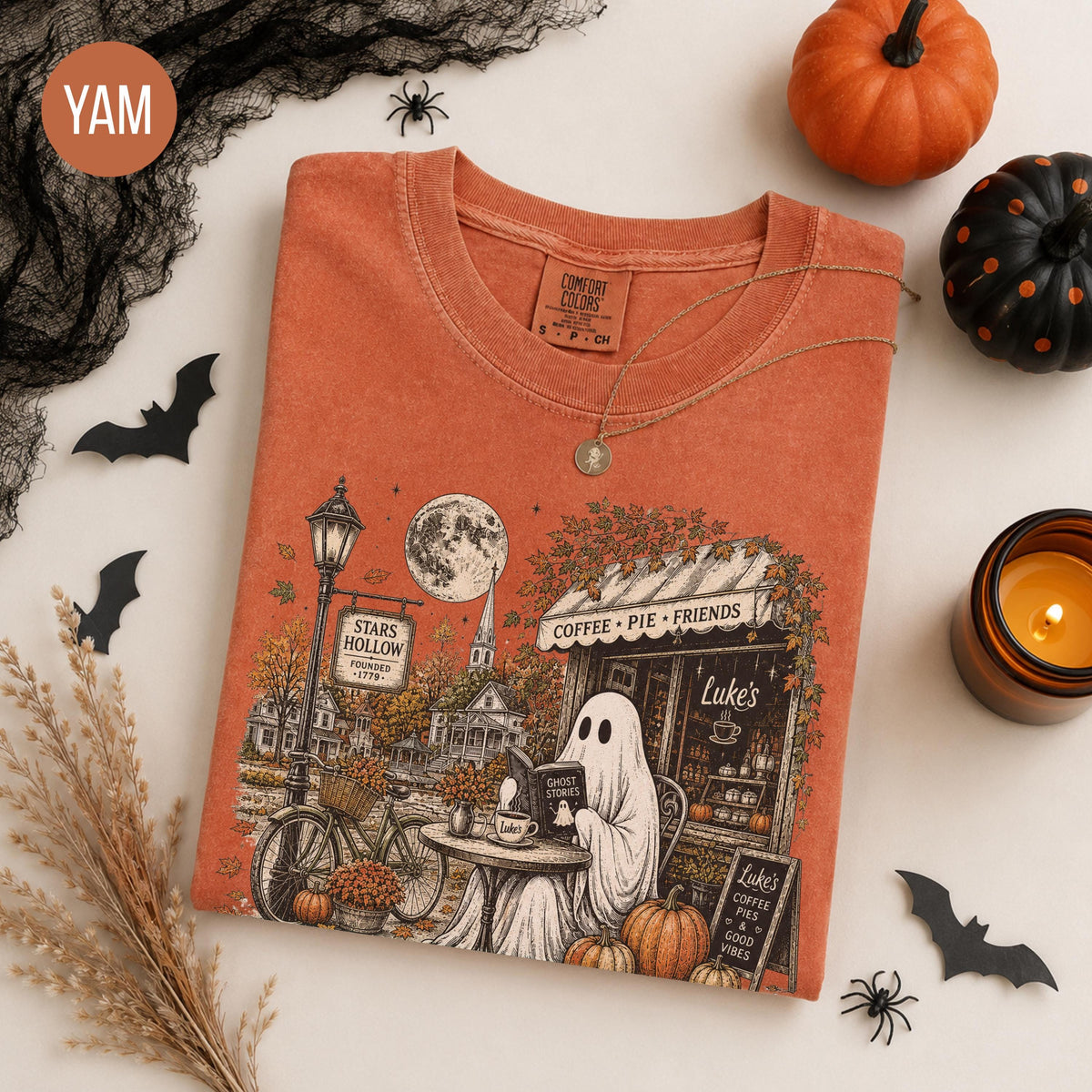 rust orange graphic tee with autumn village and bicycle