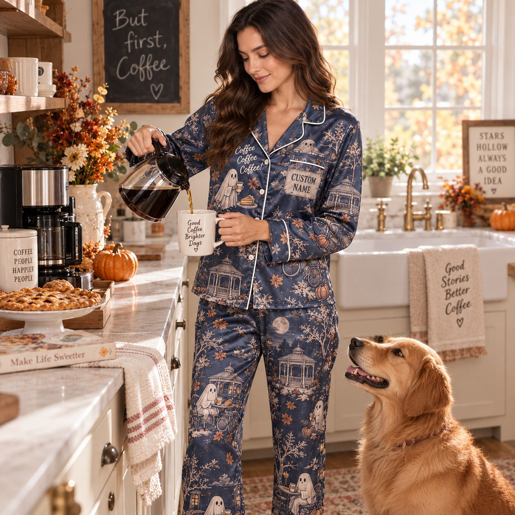 woman in the navy satin pajama set sitting on a cream chair