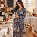 woman in the navy satin pajama set sitting on a cream chair