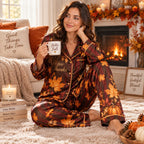 woman sitting on bed holding a mug in printed satin pyjamas