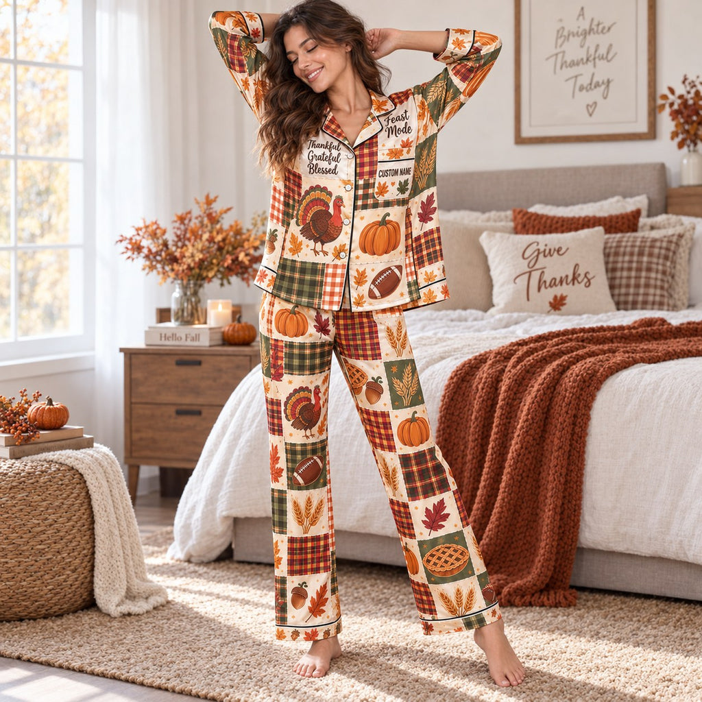 woman in thanksgiving satin pajamas sitting on couch holding pumpkin spice mug