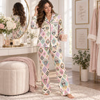 woman standing by a fireplace in the pastel ghouls satin pajama set