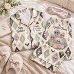 cream harlequin skull satin pajamas flat lay with a custom name on the chest