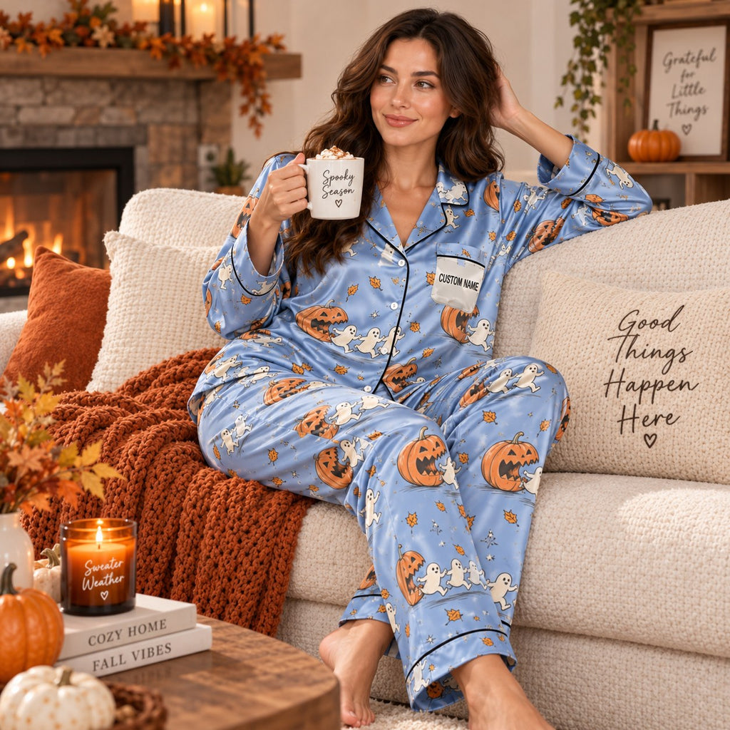 model in matching pumpkin ghost pajamas sitting on couch with hot cocoa