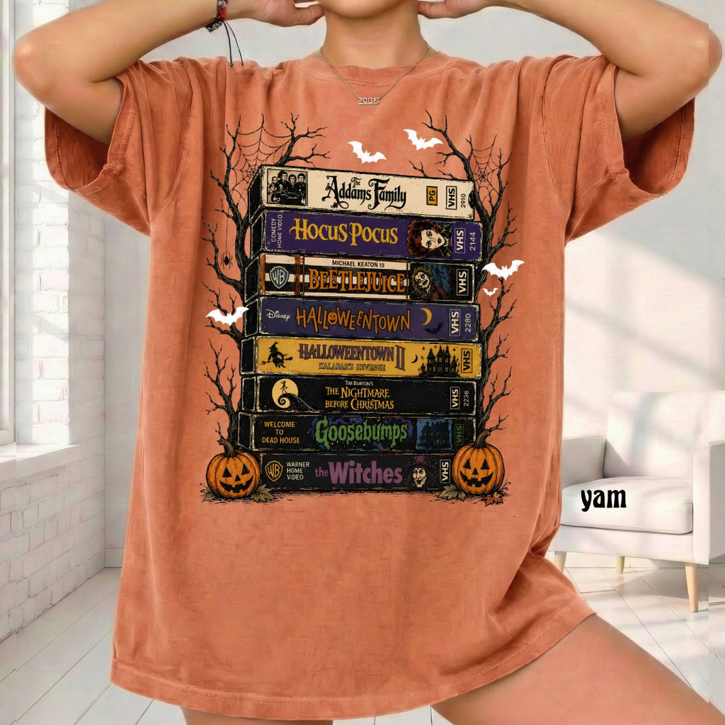 rust orange graphic tee with stacked halloween vhs tapes, pumpkins and bats