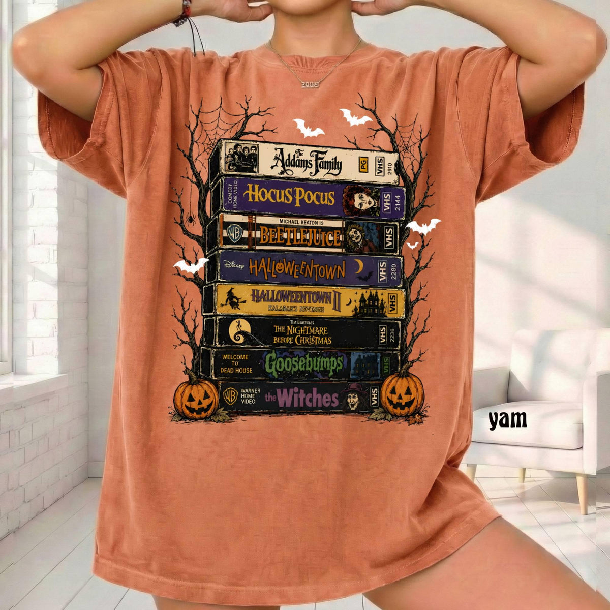 rust orange graphic tee with stacked halloween vhs tapes, pumpkins and bats