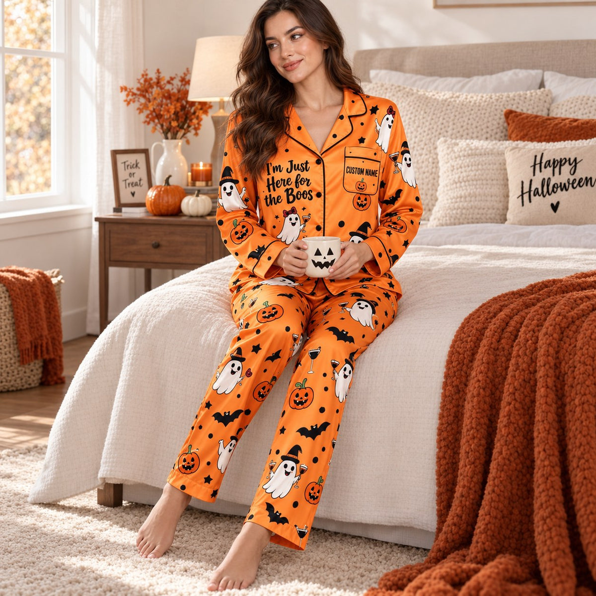 woman wearing here for the boos halloween pajamas sitting on a bed