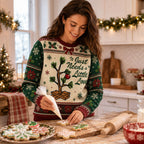 woman piping icing on festive christmas sweater while baking holiday cookies