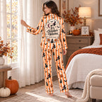 woman in halloween pajamas sitting on bed holding a good witches better