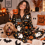 woman in a halloween satin pajama set on a bed next