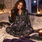 woman sitting on bed holding witchy halloween pajama mug with black cat