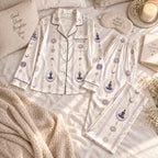 flat lay cream satin pajama set with meditation figures, lotus and moons