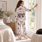 woman sitting on bed reading in a salem witch halloween pajama set