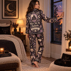 halloween satin pajama set styled on bed with mug and book