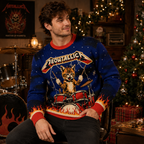 man seated wearing blue meowtallica heavy metal cat christmas sweater in festive