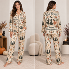 woman wearing a satin pajama set printed all over with witches, moons