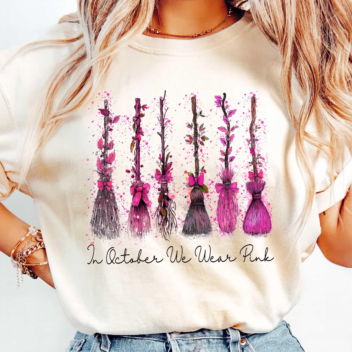cream sweatshirt with breast cancer awareness witch broom print modeled outdoors