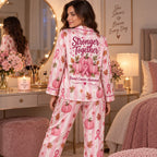 woman looking over her shoulder in pink pumpkin ribbon satin pajamas by a vanity