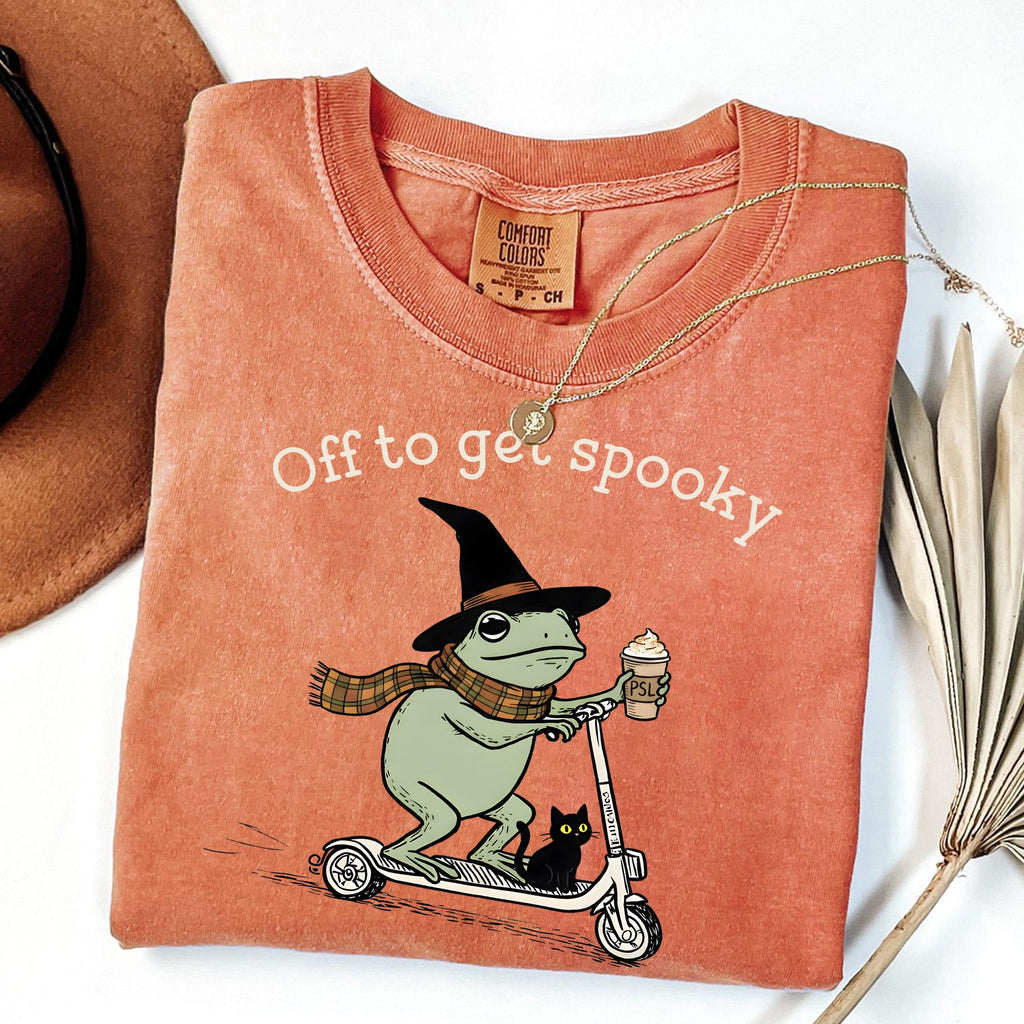 coral orange graphic tee flat lay with frog witch hat design