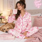 woman in pink satin pajamas holding a mug with a golden retriever