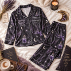 flat lay black satin pajama set with purple lavender, potions and crescent moons