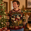 man wearing a santa and ugly christmas sweater indoors by a lit