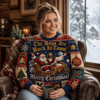 woman on a leather chair smiling in a merry christmas sweater with