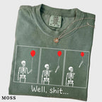 folded moss green graphic tee with skeleton and red balloon comic print