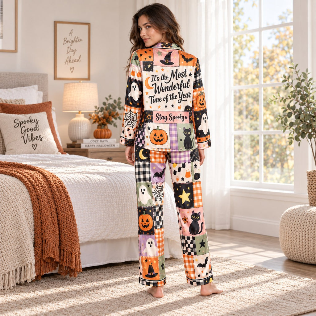 woman sitting on bed holding mug in halloween satin pajama set