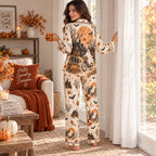 woman in matching Halloween satin pajamas holding a pumpkin mug