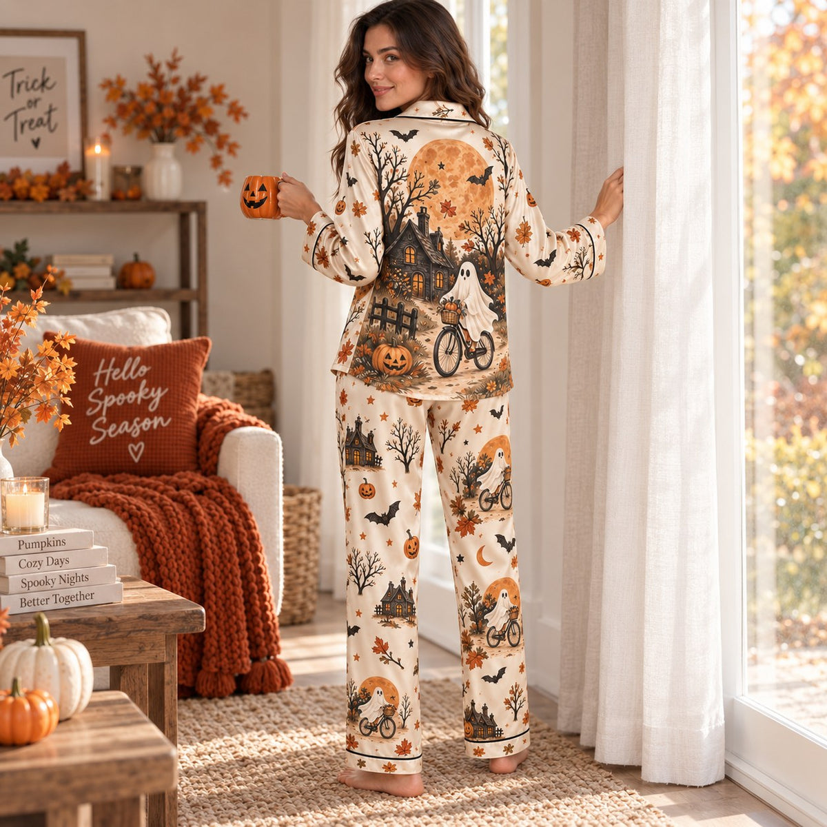 woman in matching Halloween satin pajamas holding a pumpkin mug