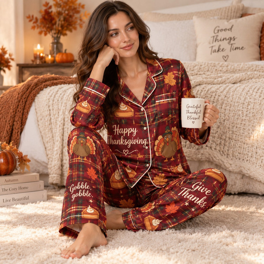 woman sitting on bed holding a mug in red satin thanksgiving pyjamas