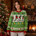 woman wearing a ugly christmas sweater by a lit tree