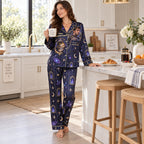 woman reading a book in matching galaxy print satin pajamas