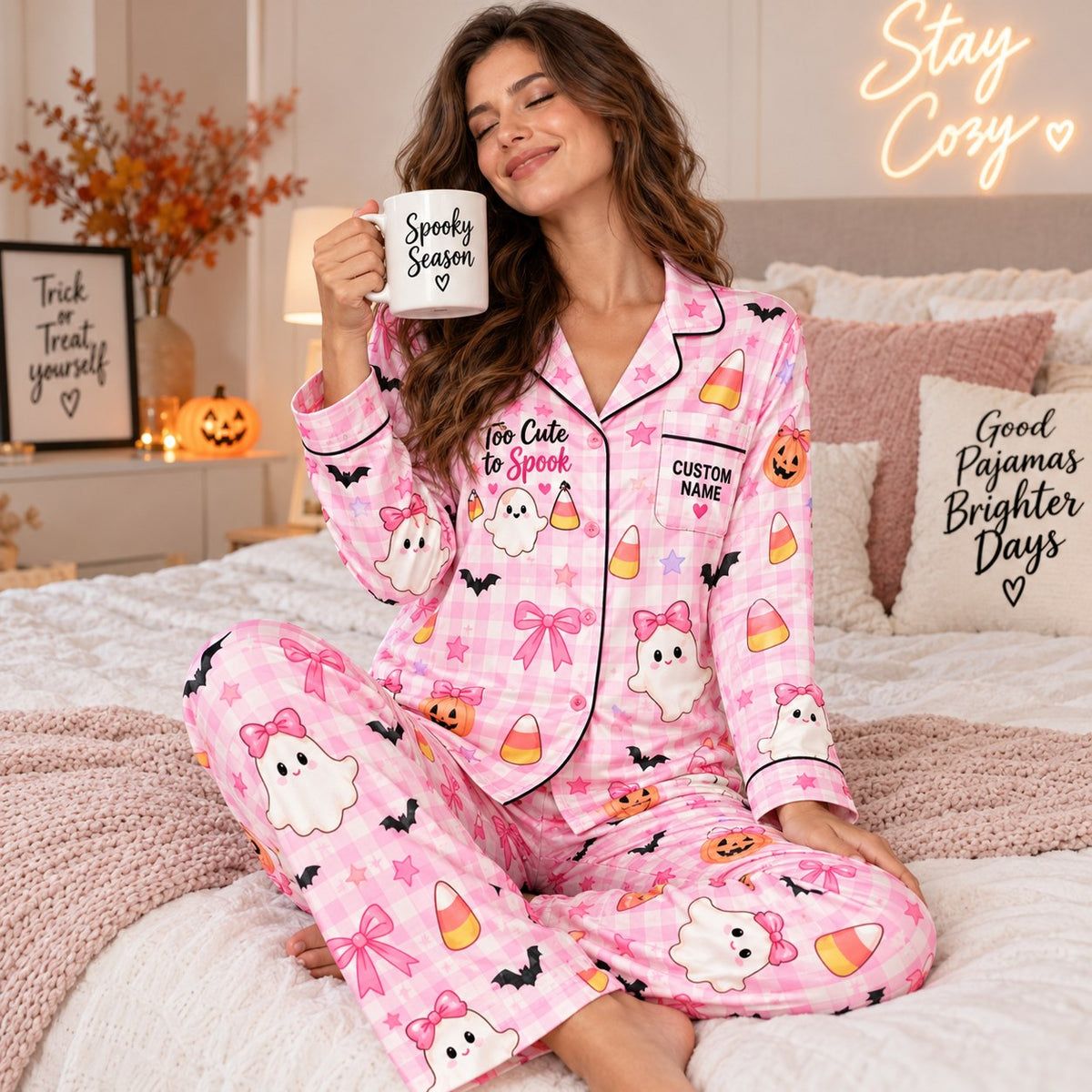 smiling woman in pink plaid halloween pajamas holding a pink ghost mug