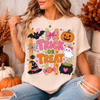 woman wearing a cream halloween graphic tee with trick or treat doodles