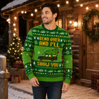 smiling man modeling the ugly christmas sweater in front of a snowy