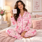 woman in pink ribbon pajamas sitting on bed holding a mug