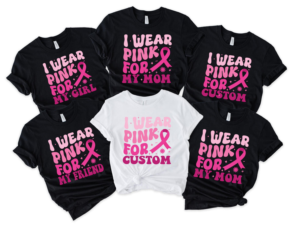 pile of black and white graphic tees reading i wear pink for