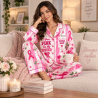 woman holding a coffee mug in a bedroom wearing the breast cancer