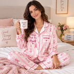 satin pajama set survivor drinking from a heart mug on a bed