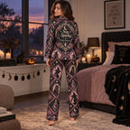 woman sitting on bed in a personalized witchy woman halloween satin pajama