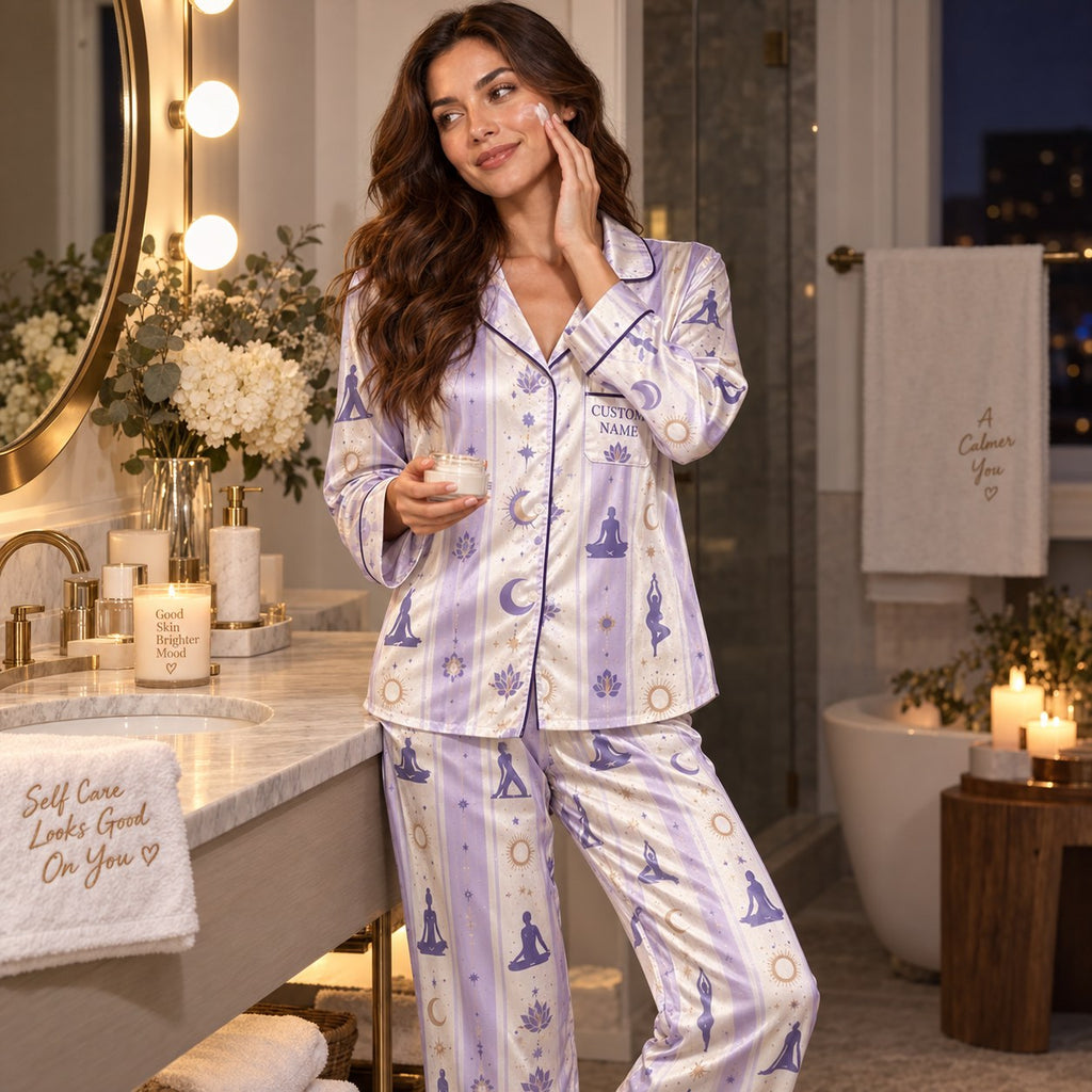 woman sitting on a bed in a striped satin pajama set